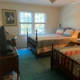 Bedroom 2 has a queen and a twin bed, plus a TV and ceiling fan.