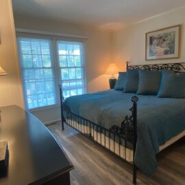 The master bedroom has a king size bed with linens provided. There is also a TV.